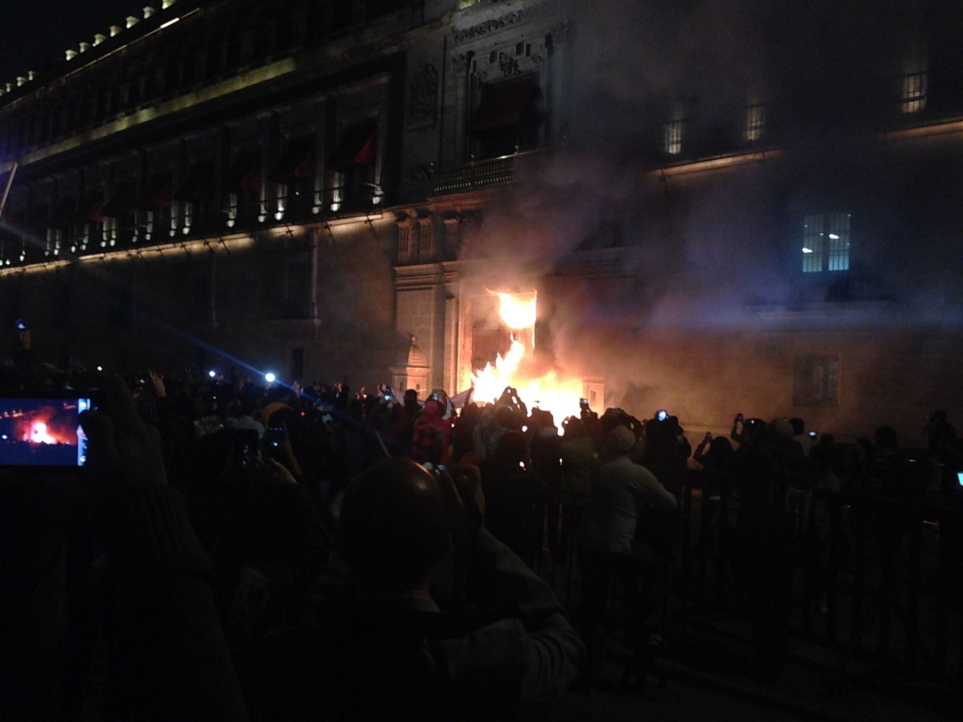 Manifestantes que salieron de la PGR en apoyo a los normalistas de Ayotzinapa quemaron la puerta de Palacio Nacional la noche del 8 de noviembre de 2014. 