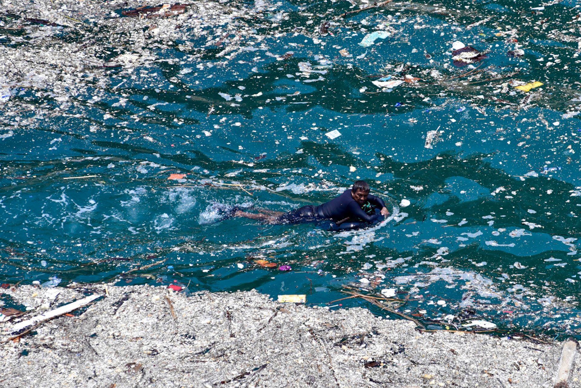 Abril, 2014.- Un buzo nada entre una capa espesa de basura, que flota en la playa La Angosta de Acapulco.