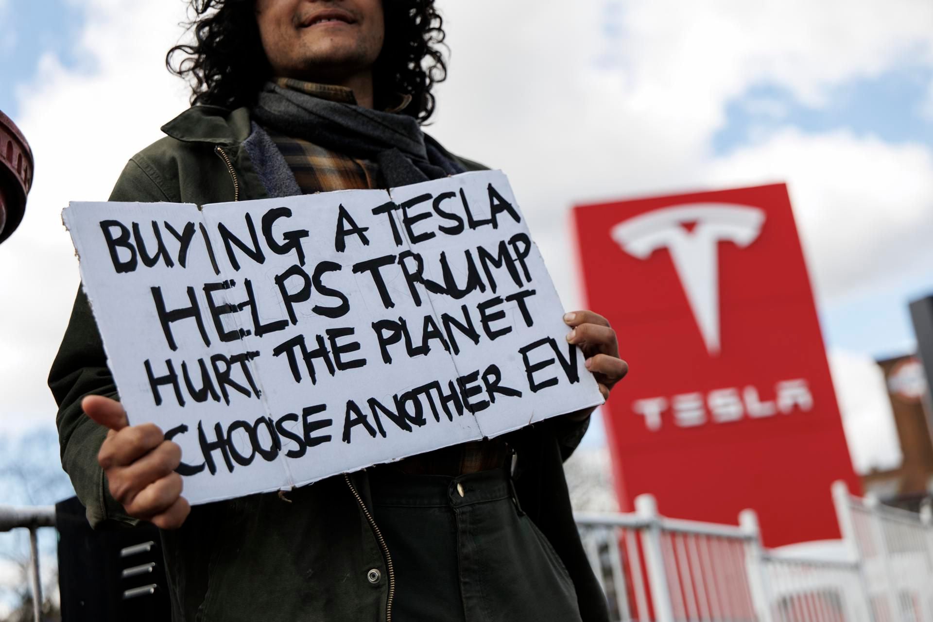 Manifestantes frente a un concesionario de Tesla para protestan contra Elon Musk y su papel en la administración del presidente de EU, Donald Trump. 