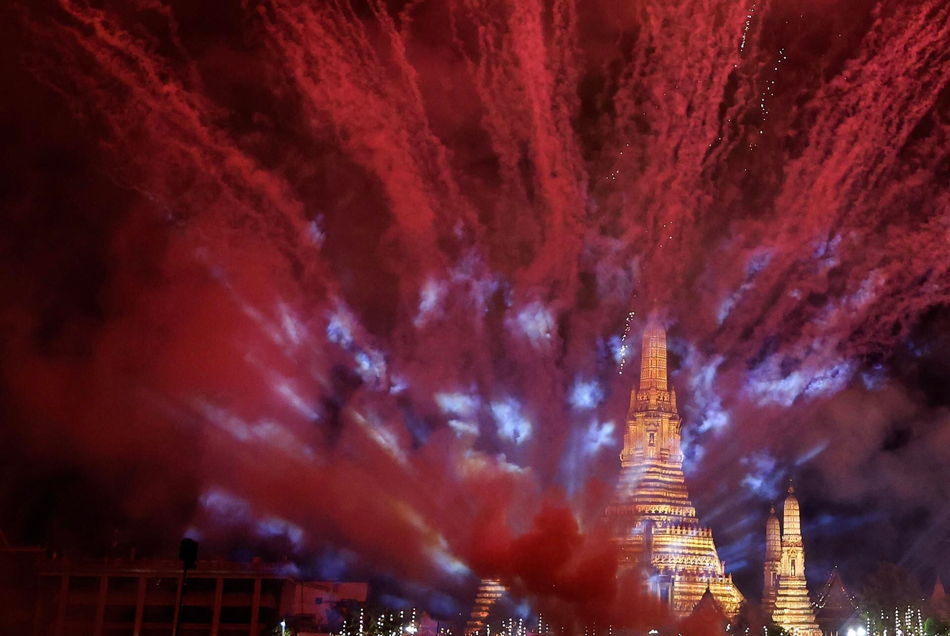 Fuegos artificiales y luces sobre la pagoda del Templo del Amanecer como parte de las celebraciones de Año Nuevo, en Bangkok. 