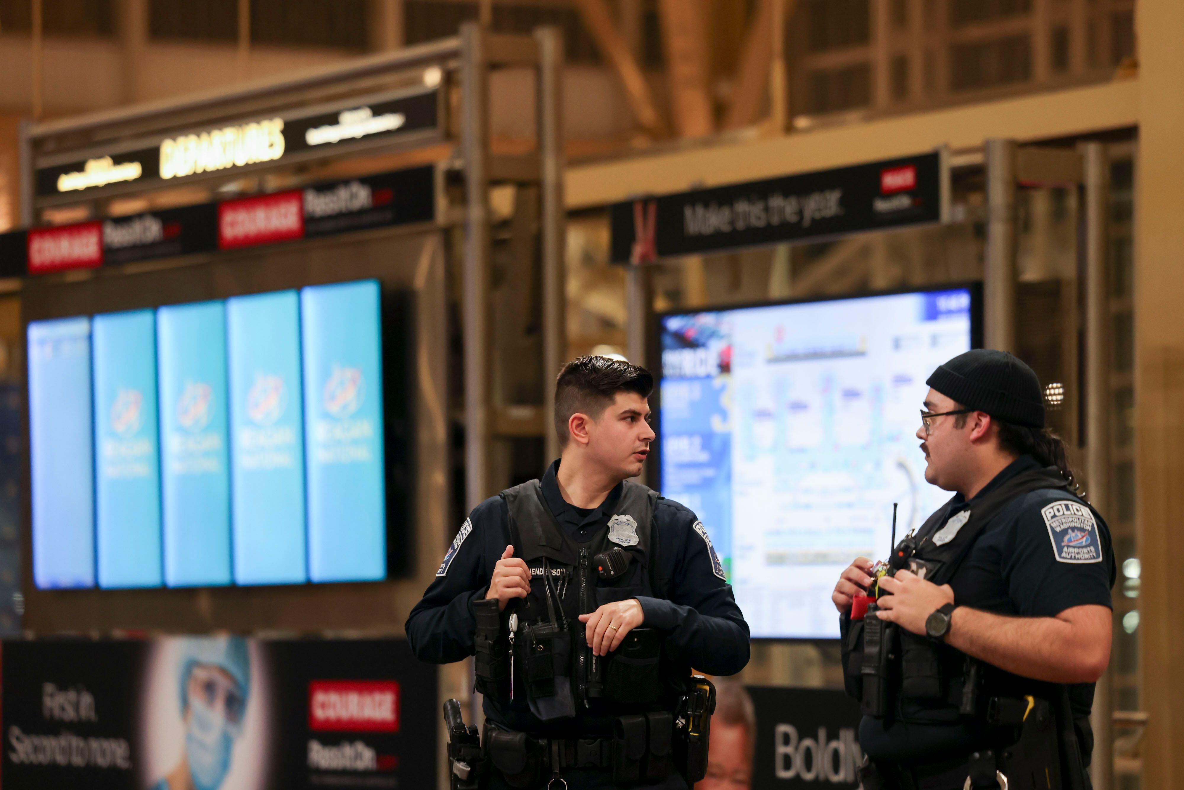 Policías resguardaron el aeropuerto Ronald Reagan tras la suspensión de operaciones por el accidente aéreo en Washington.