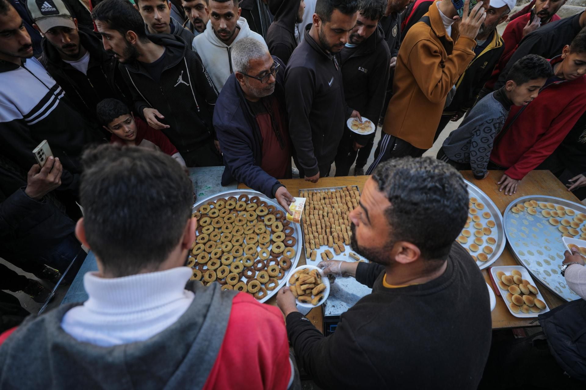 Vendedores palestinos ofrecen dulces en las calles del campo de refugiados Al Nusairat, en Gaza, este 11 de marzo, tras el inicio del Ramadán.