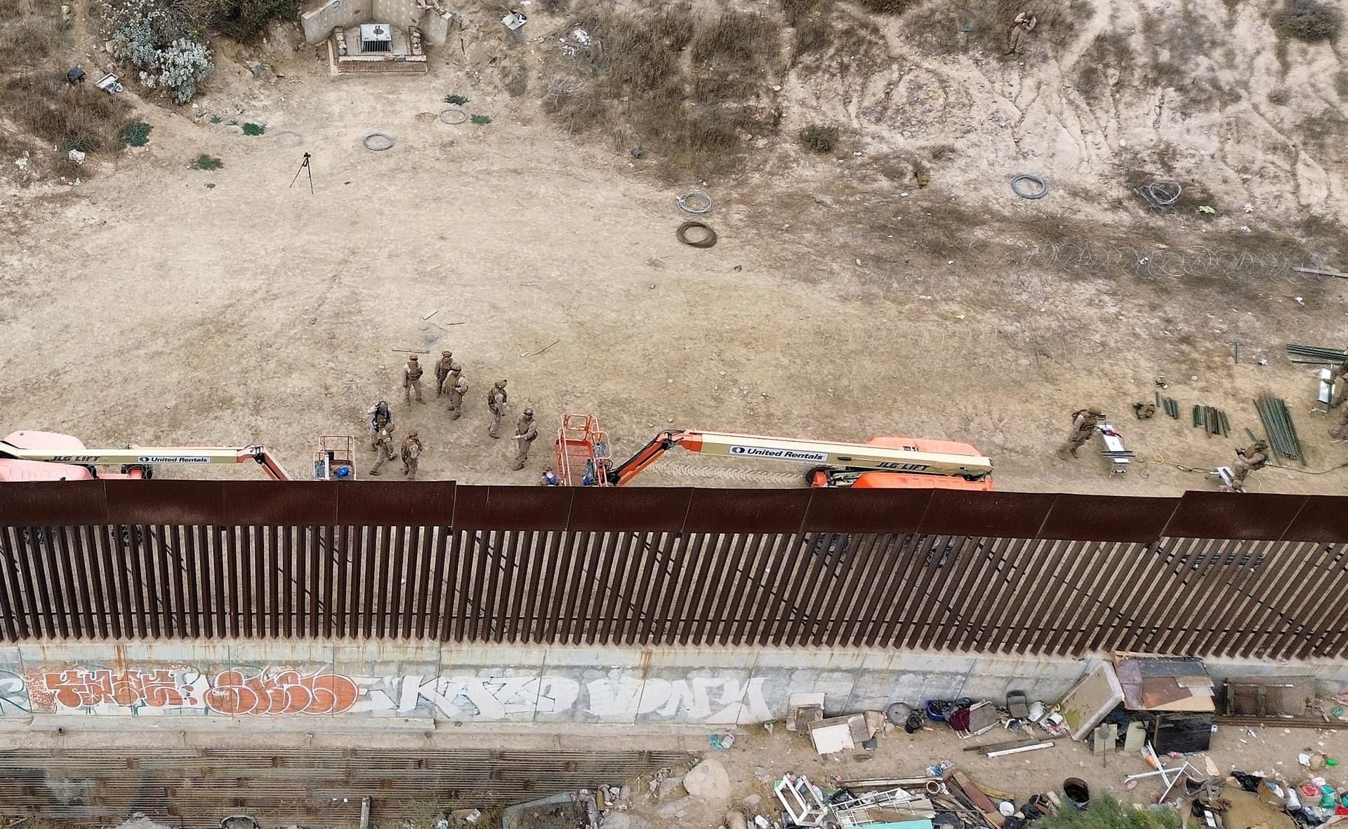 Fotografía aérea donde se observa a integrantes del ejército de Estados Unidos reforzando un muro con alambre de púas este jueves, en la frontera con la ciudad de Tijuana, en Baja California (México). (Foto: EFE/ Joebeth Terríquez)
