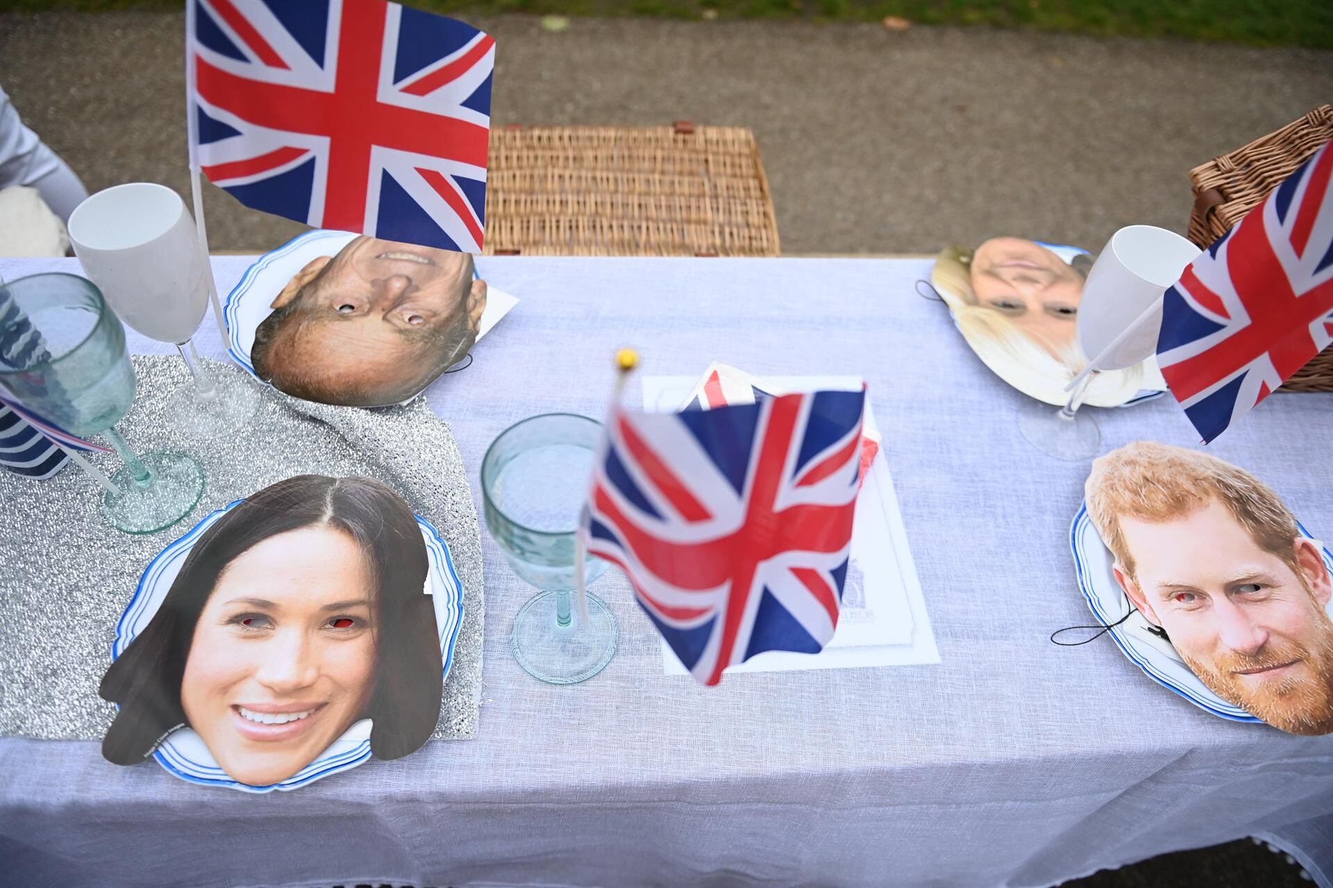 Máscaras que representan a los miembros de la realeza británica se muestran en una mesa mientras la gente disfruta de un picnic mientras participan en El Gran Almuerzo en el Largo Paseo durante las celebraciones del Jubileo de Platino de la Reina Isabel II de Gran Bretaña, en Windsor, Gran Bretaña. (Foto: EFE/EPA/NEIL HALL)