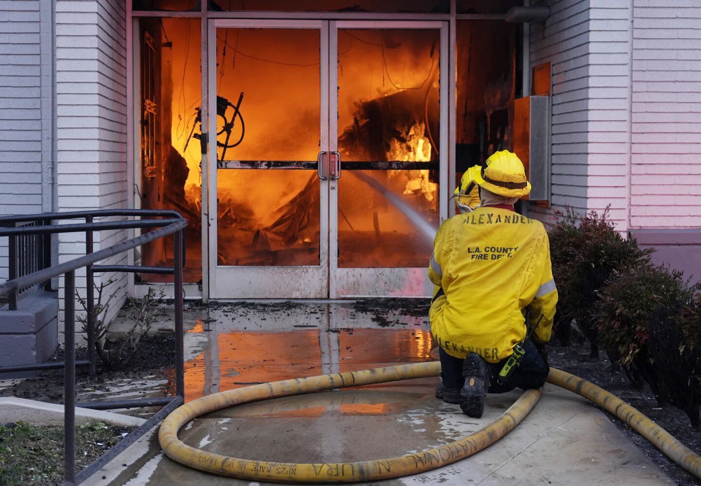 Bomberos combaten un incendio en la entrada de una sucursal de Bank of America envuelta en llamas en Lake Avenue, en Pasadena, California. Foto: AP