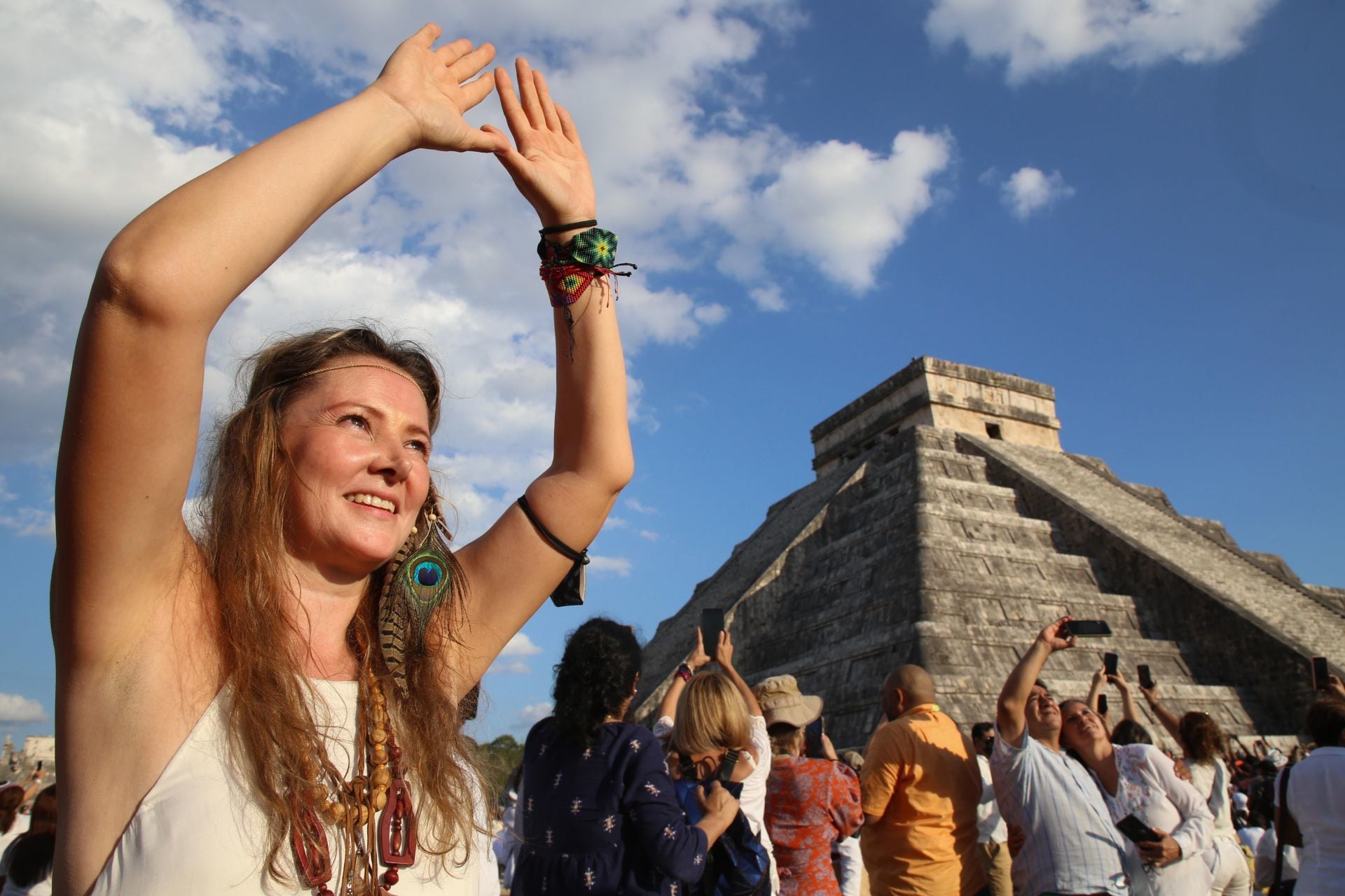 Turistas extranjeros y nacionales reciben el equinoccio de primavera en la zona arqueológica de Chichén Itzá.