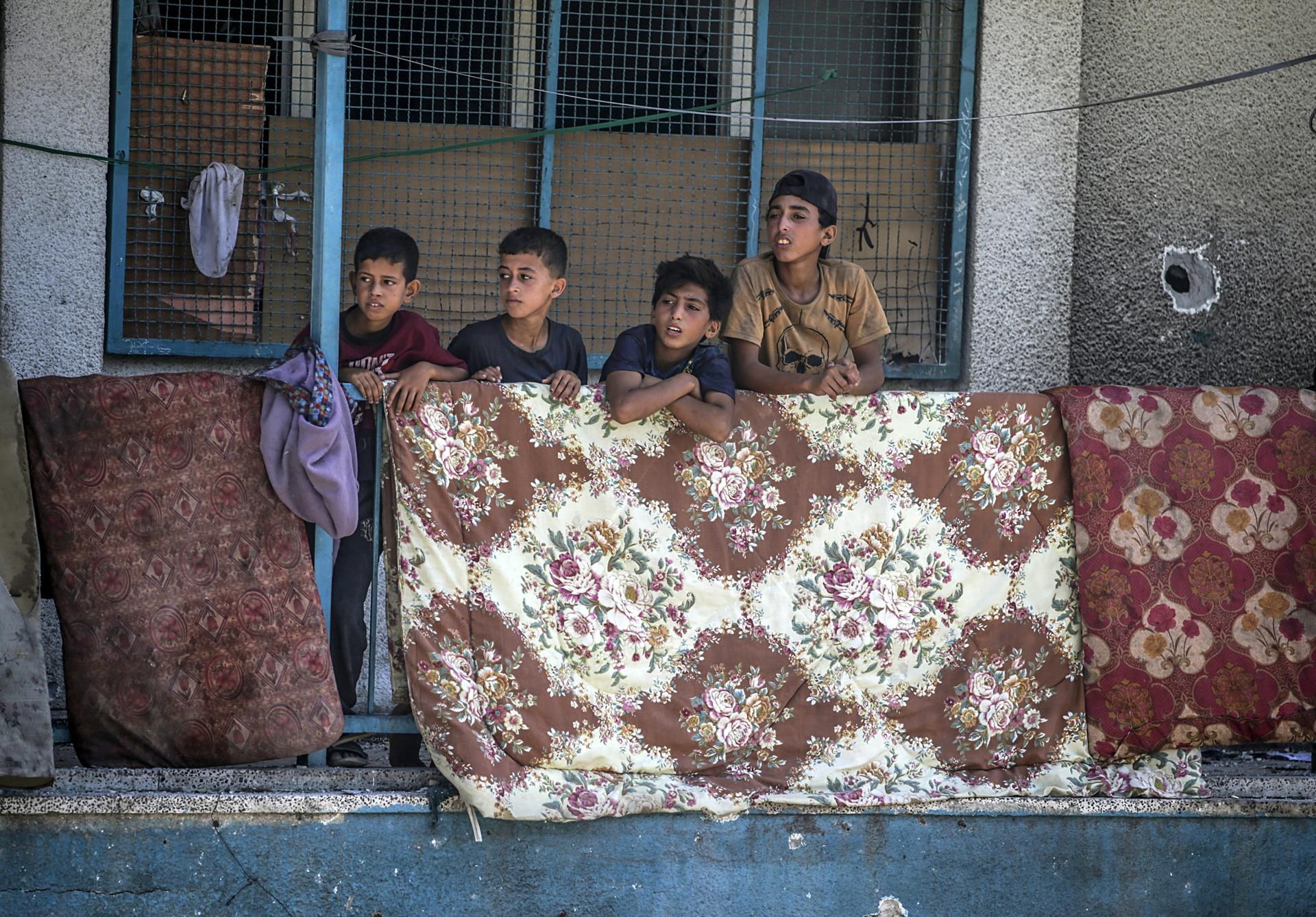Niños palestinos se asoman en la escuela de la UNRWA en Nuseirat, bombardeada por Israel durante la madrugada.