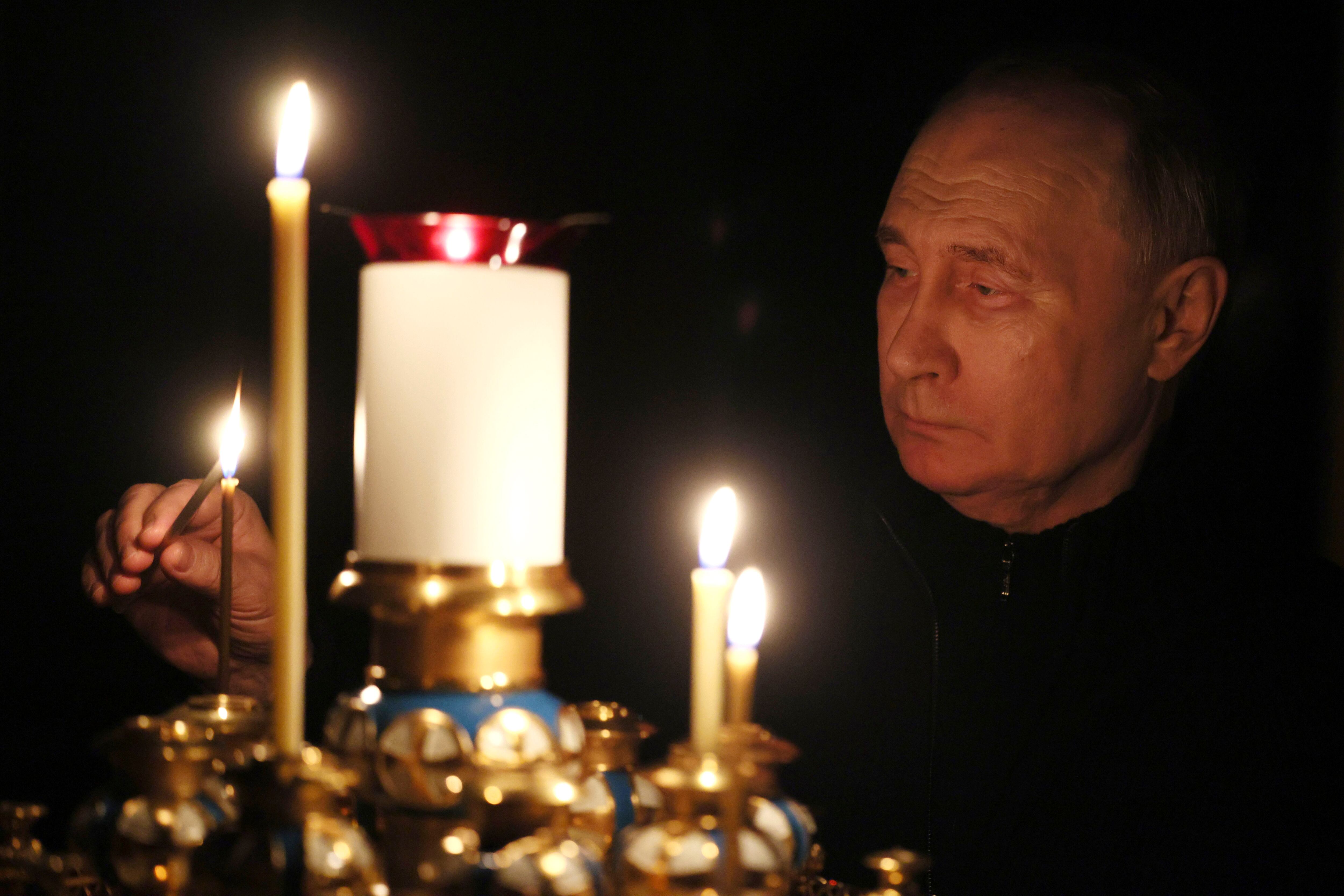 El presidente Vladimir Putin enciende una vela en memoria de las víctimas de un ataque a la sala de conciertos Crocus City Hall