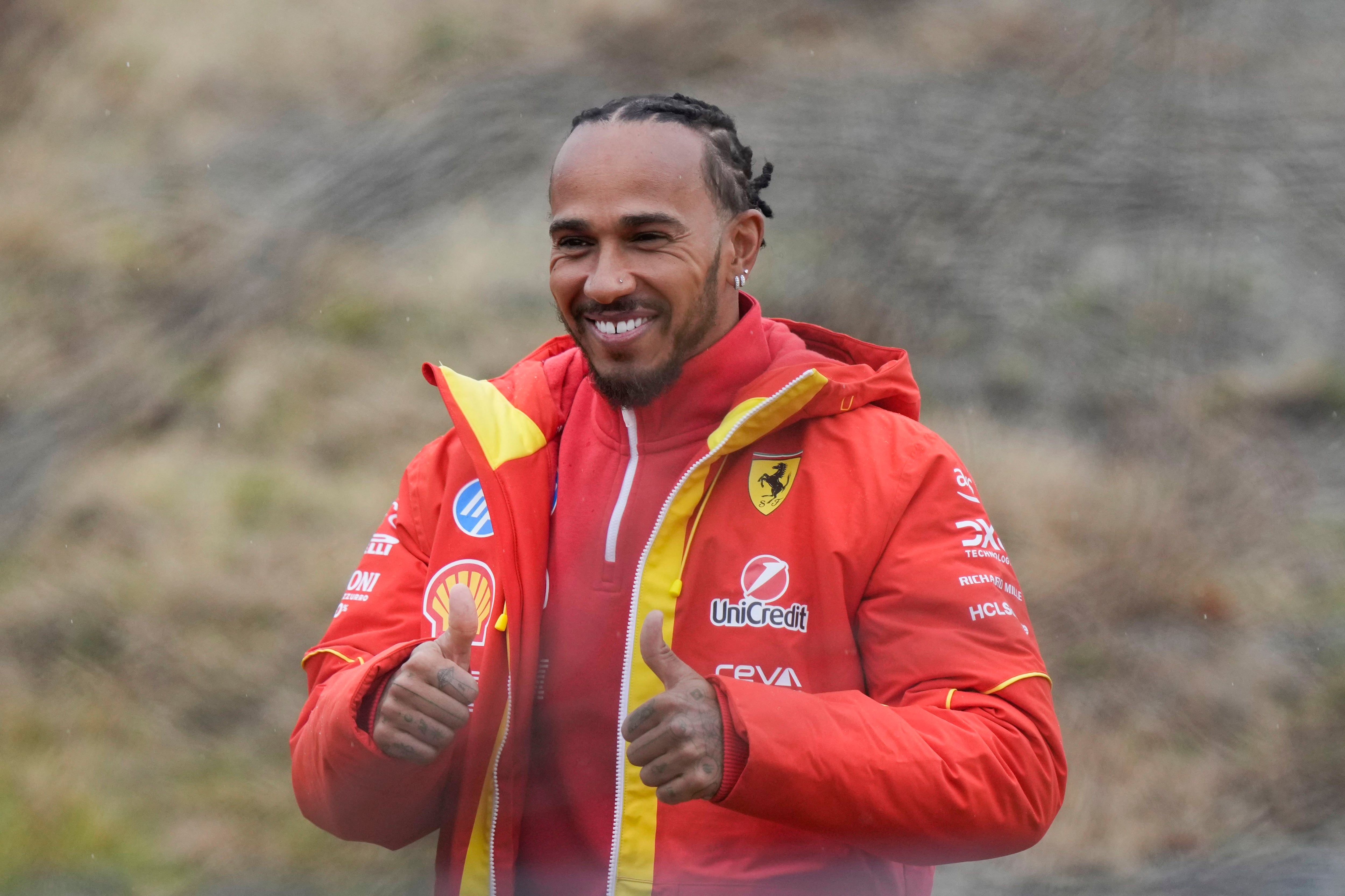 Lewis Hamilton saluda a los fanáticos de Ferrari afuera de la pista tras realizar una prueba con el modelo SF-23, en Fiorano Modenese, Italia, el miércoles 22 de enero de 2025. (AP Foto/Luca Bruno)