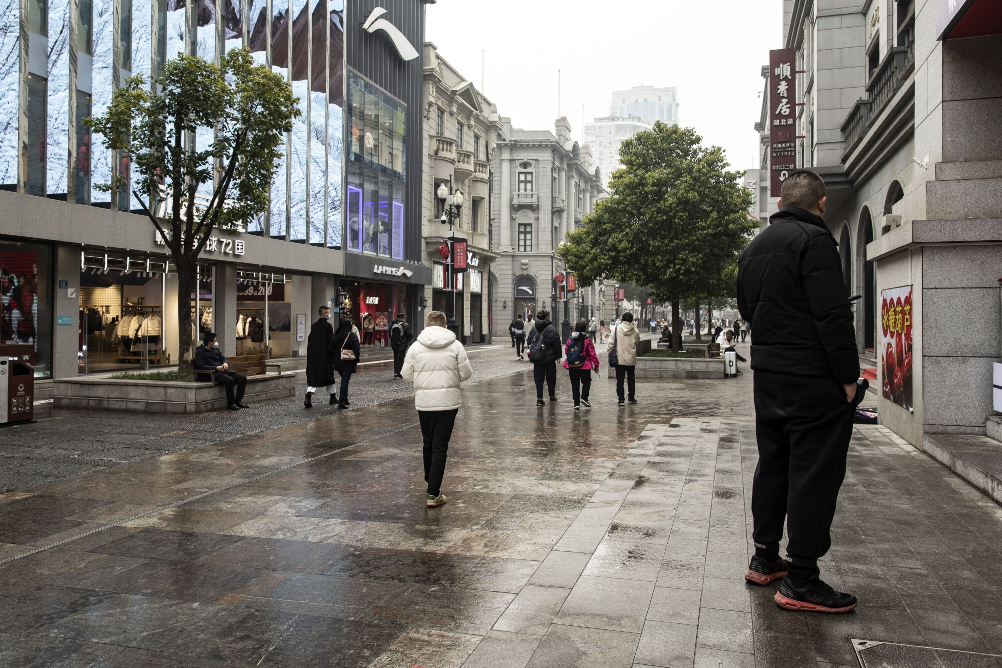 Personas visitan una de las zonas comerciales más populares de Wuhan, considerada como la 'cuna' del COVID-19.