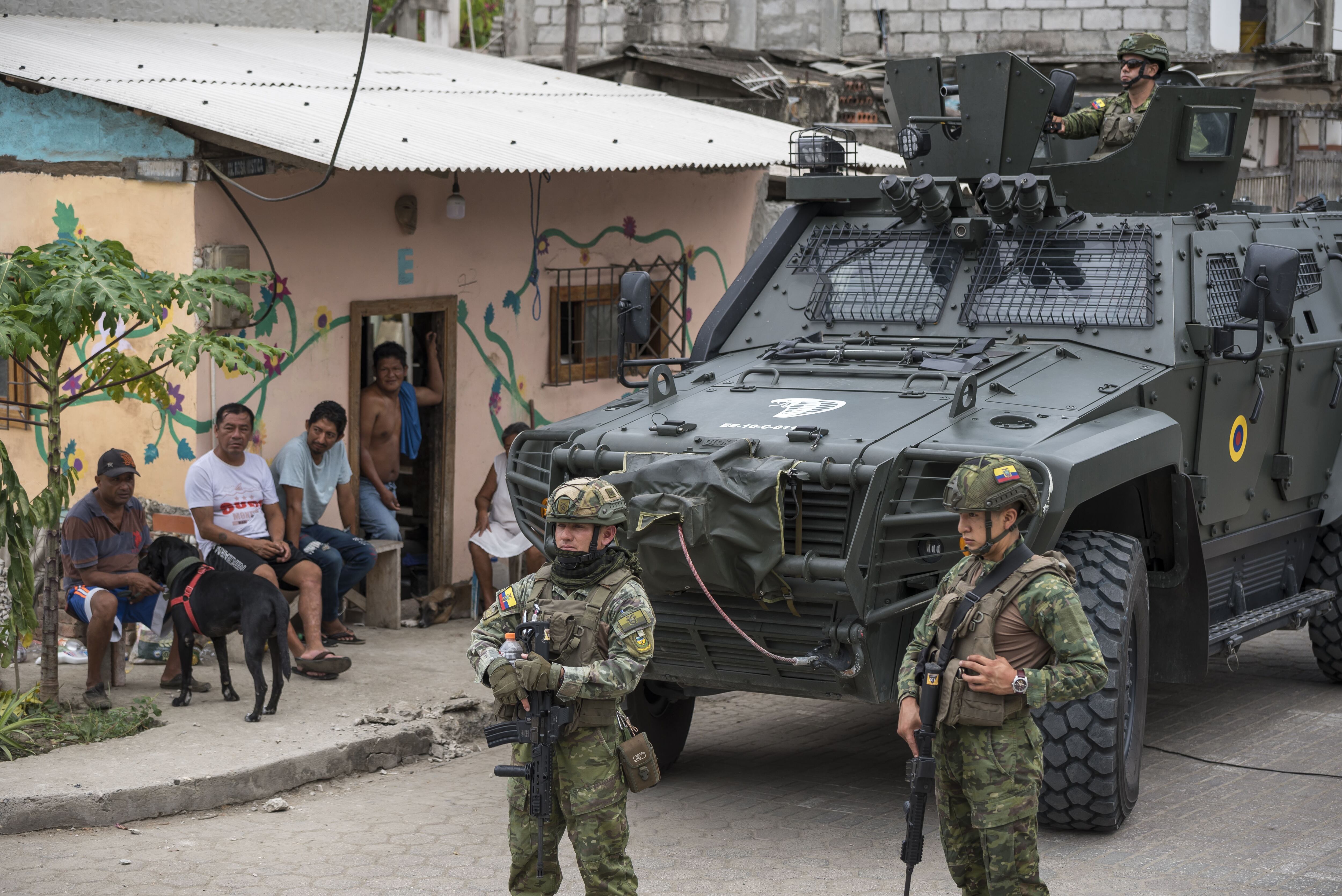Miembros del ejército hacen guardia frente a un colegio electoral durante el referéndum nacional en Olón el domingo.