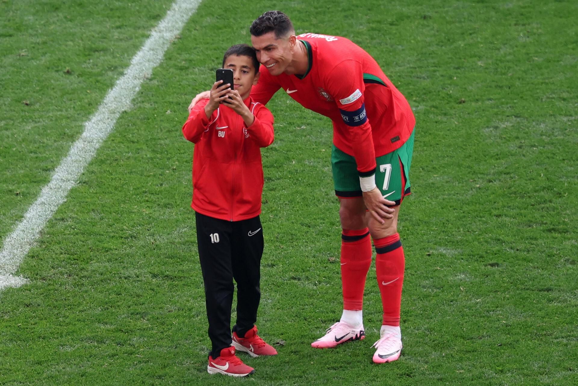 Cristiano Ronaldo recibió de buena forma al niño que invadió la cancha en el partido entre Turquía y Portugal. (Foto: EFE).
