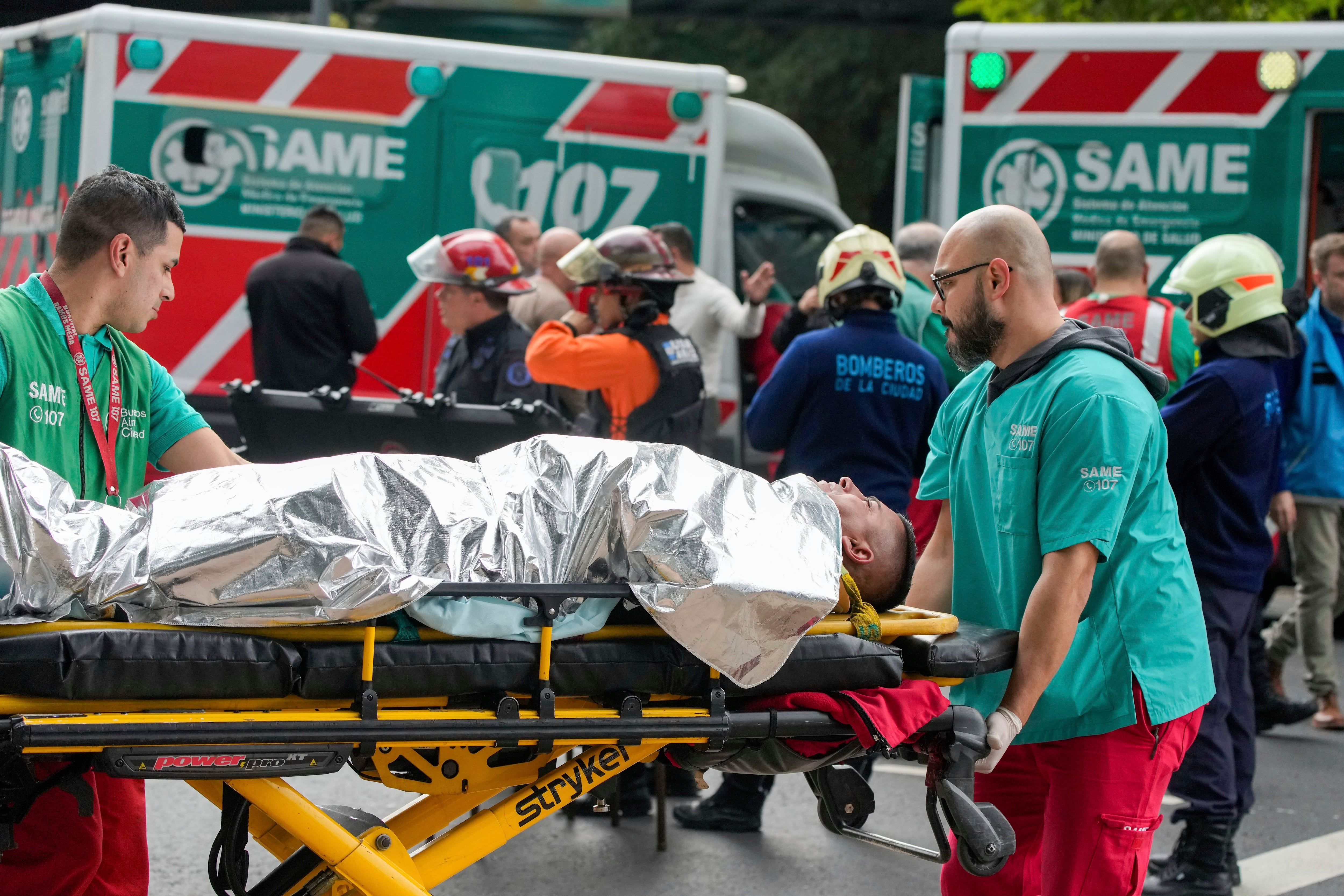 Paramedics transport injured travelers after two trains collide in Buenos Aires.