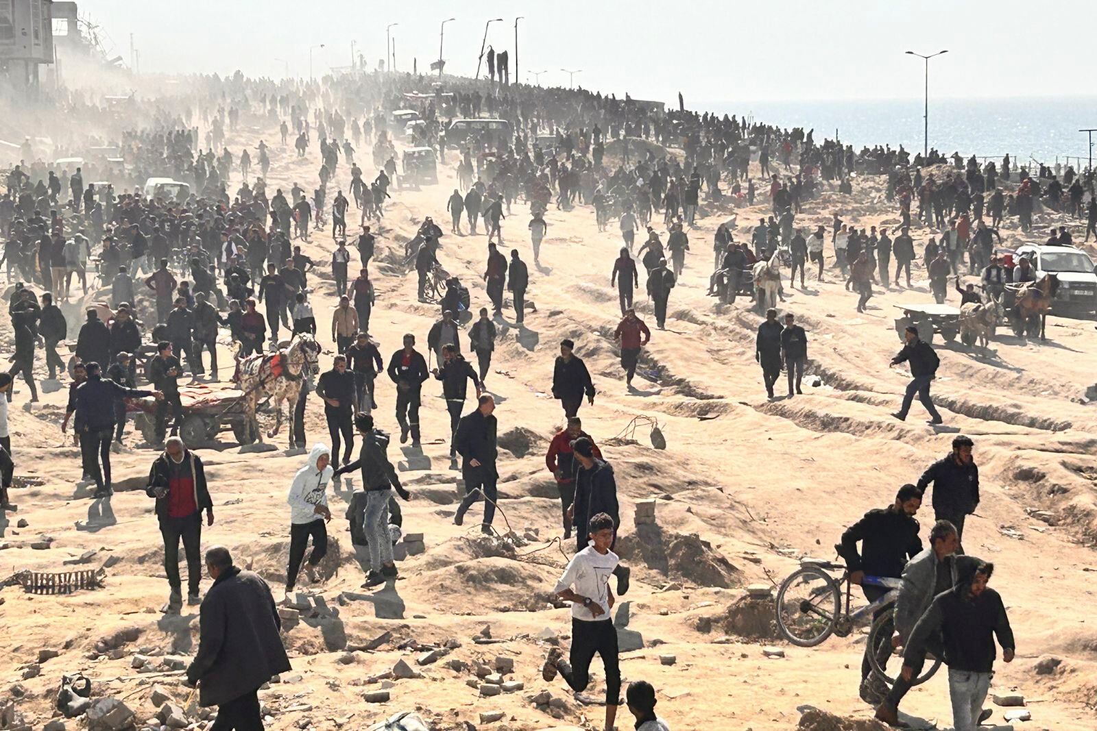 Palestinos esperan a recibir ayuda humanitaria en una playa en Ciudad de Gaza, en la Franja de Gaza, el domingo 25 de febrero.