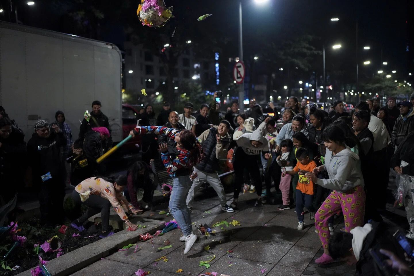 Una mujer golpea una piñata tradicional, dada por voluntarios conocidos, como los Reyes Punk, que distribuyen, juguetes, ropa y piñatas, a niños desfavorecidos. Foto: AP