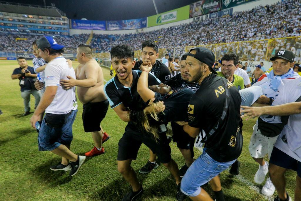Un grupo de hinchas carga a un aficionado herido hacia la cancha del estadio de Cuscatlán en San Salvador, el sábado 20 de mayo de 2023. (Foto: AP / Milton Flores)
