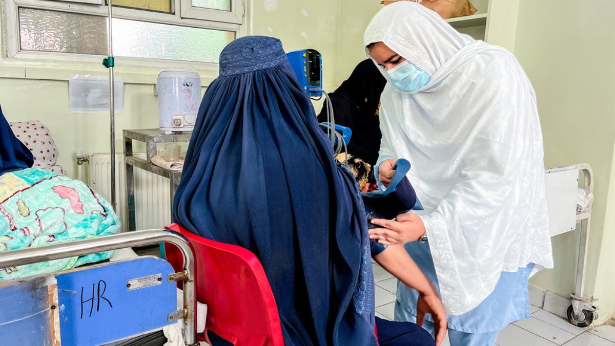 Una enfermera de MSF coloca un brazalete para medir la presión arterial en el brazo de una mujer para verificar su presión. (Foto: Paul Odongo/ MSF)