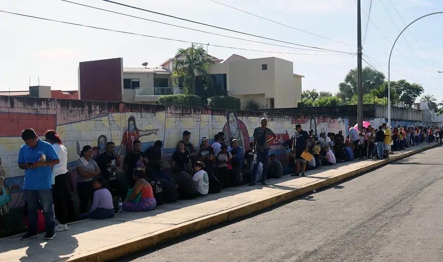 Los migrantes esperan en una fila para resolver su situación migratoria, en la ciudad de Tapachula (México). EFE/Juan Manuel Blanco