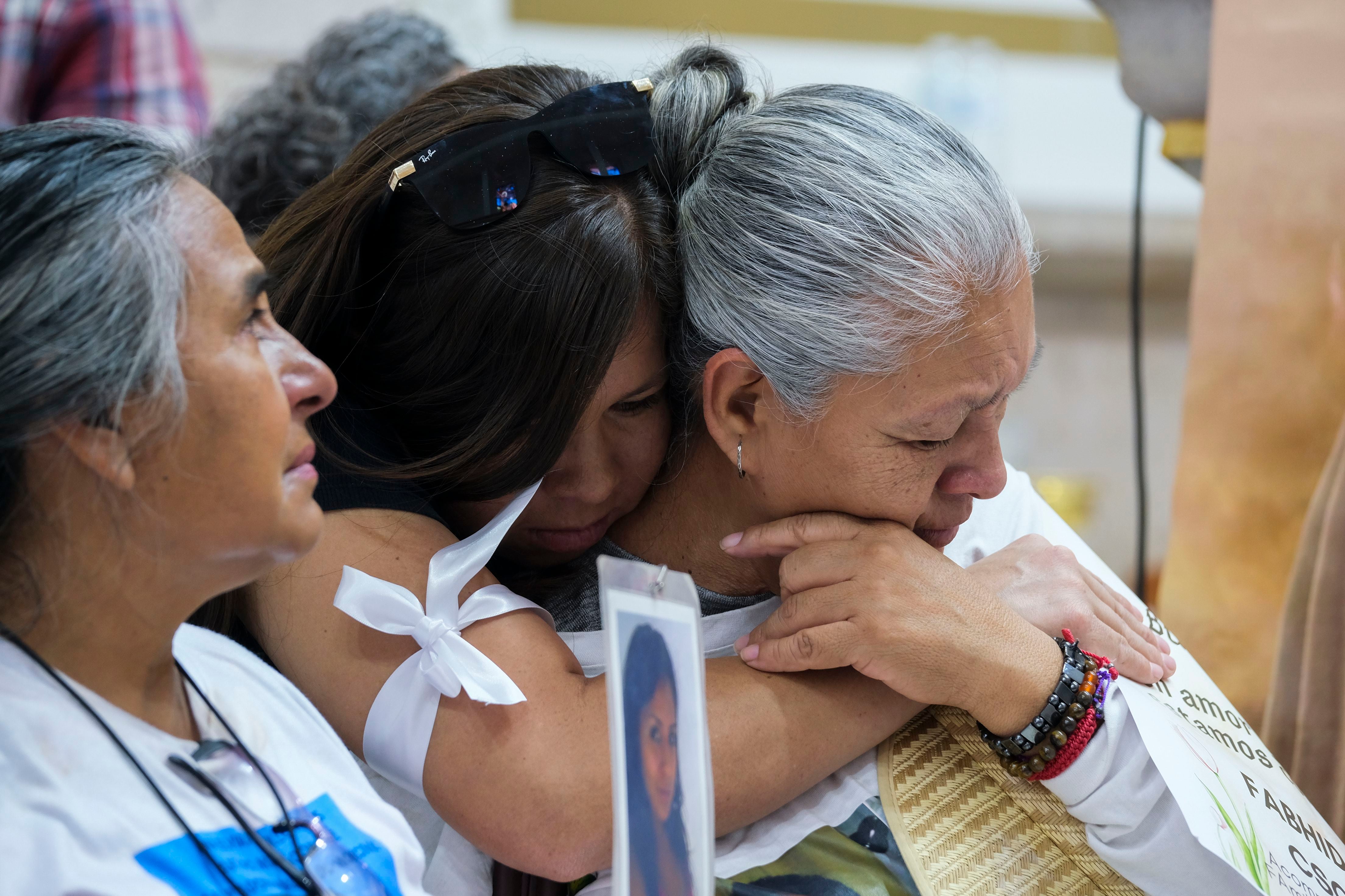 Feligreses se abrazan durante una misa tras el descubrimiento de los restos óseos de sus seres queridos en el Rancho Izaguirre en Teuchitlán.