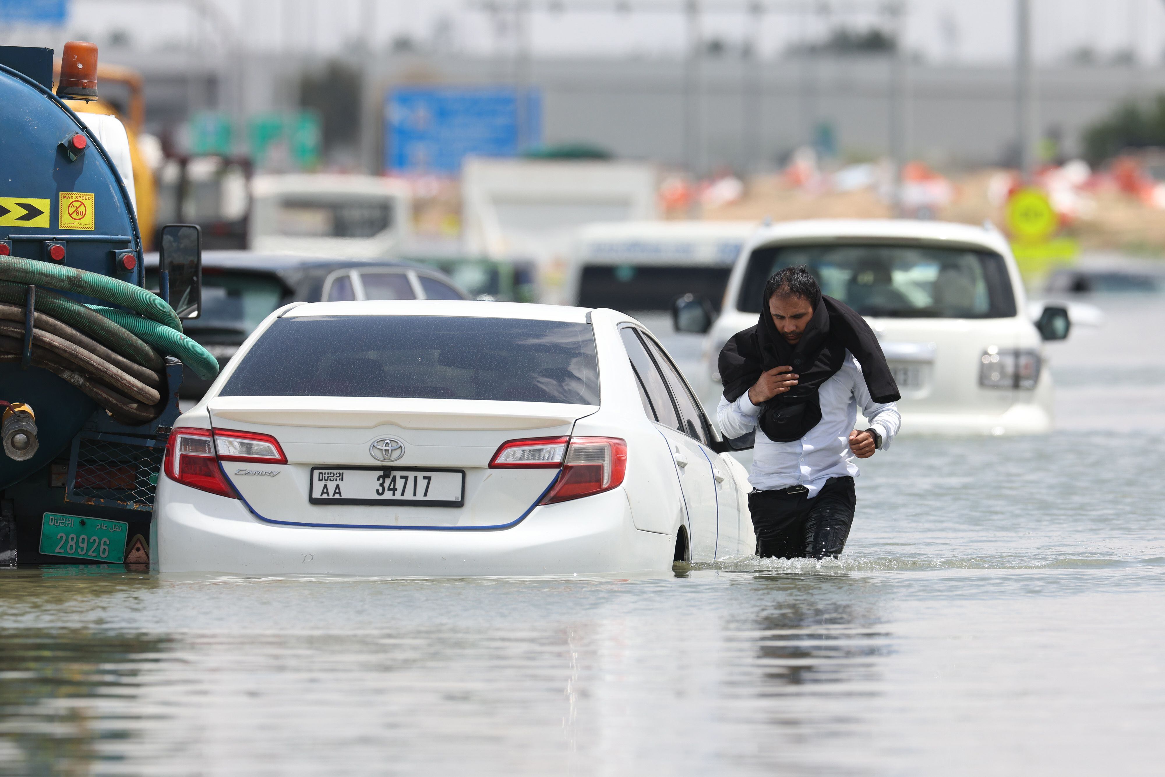 Un conductor camina entre aguas altas después de abandonar su vehículo tras una tormenta en Dubái, Emiratos Árabes Unidos.