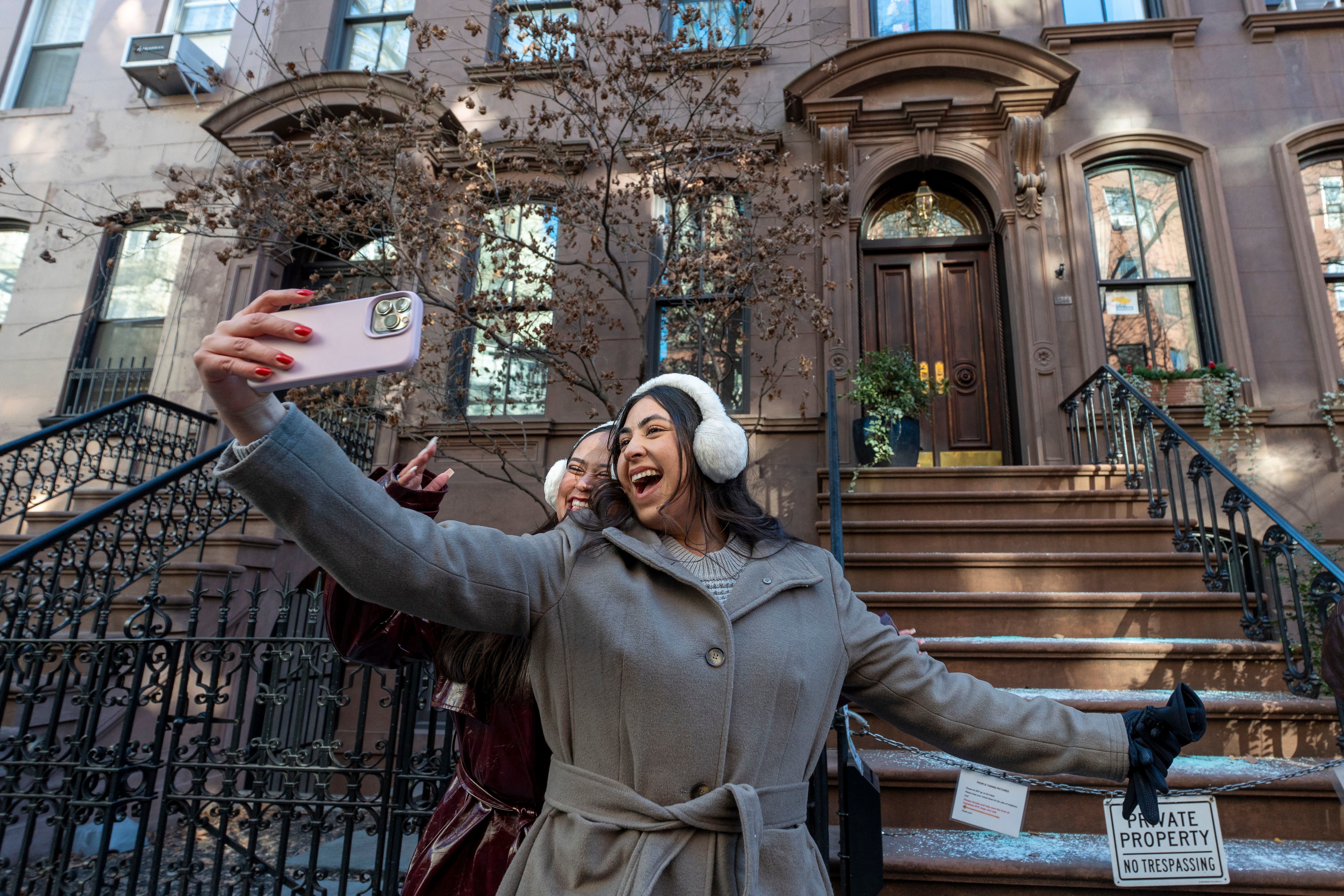 Una pareja de turistas se toma fotos este martes, frente a la casa donde se grabó la serie ´Sex and the City´, en Nueva York (Foto: EFE/ Ángel Colmenares) 