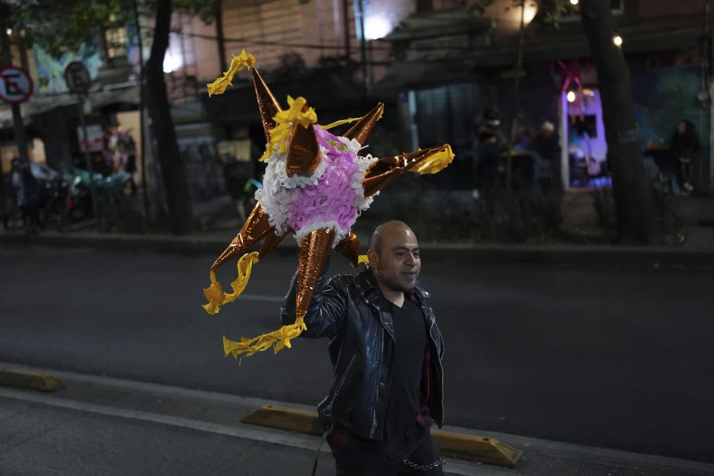 Un voluntario del grupo conocido como Reyes Punk, carga un piñata para los niños desfavorecidos. Foto: AP