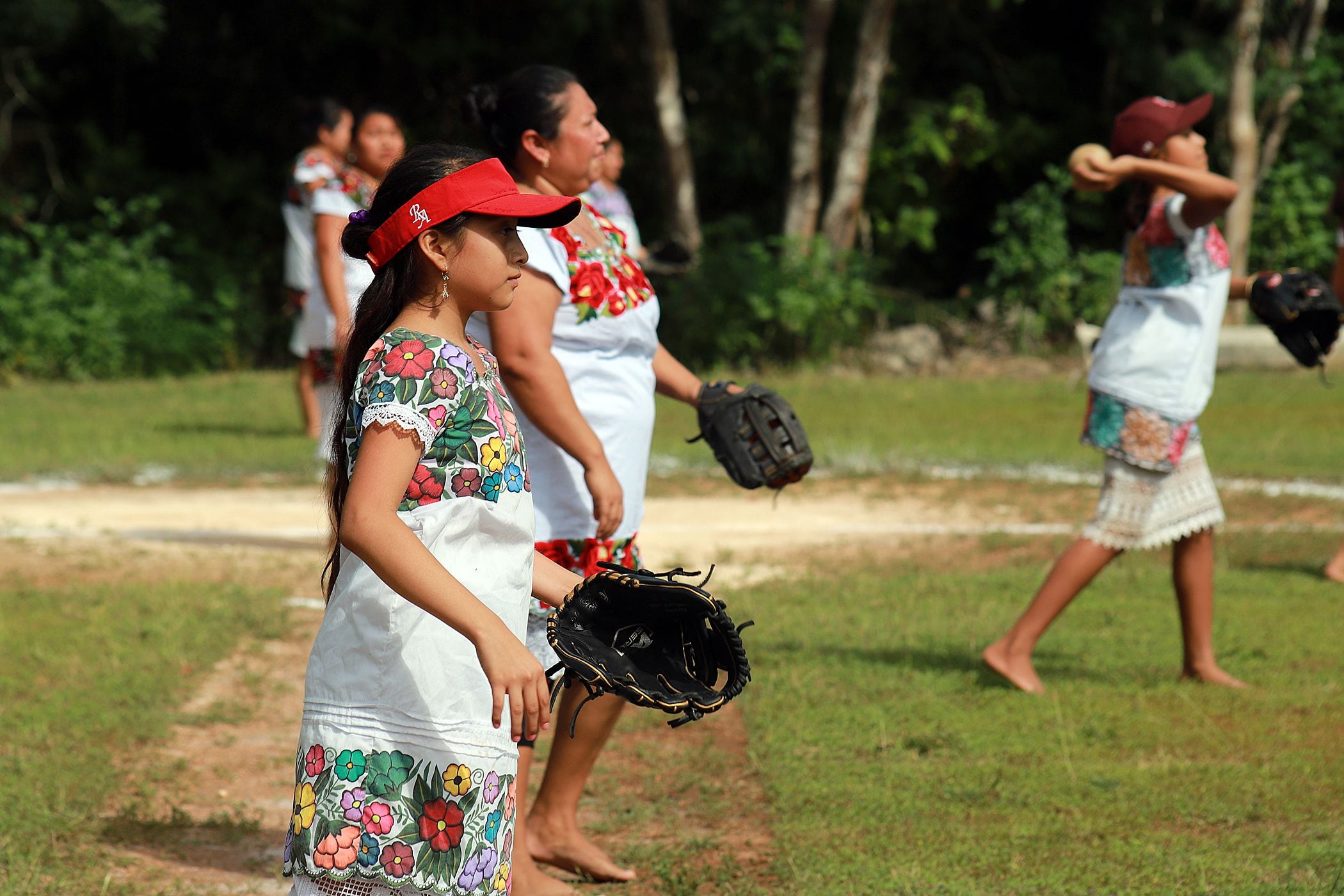 Jugadoras del equipo Diablillas Mestizas de Hondzonot participan en un juego de sóftbol. (Foto:EFE/ Lourdes Cruz)