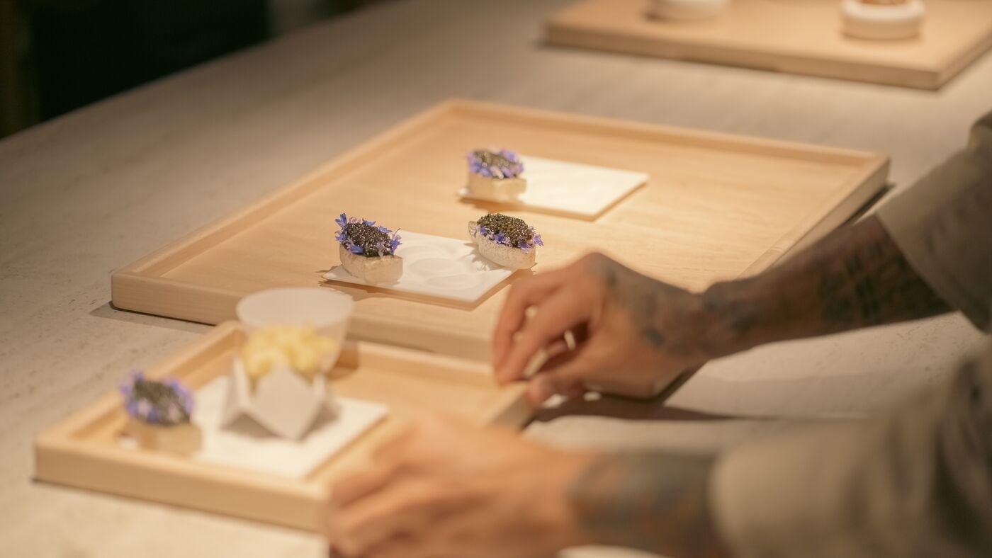 Un chef de Somni emplatando canapés.