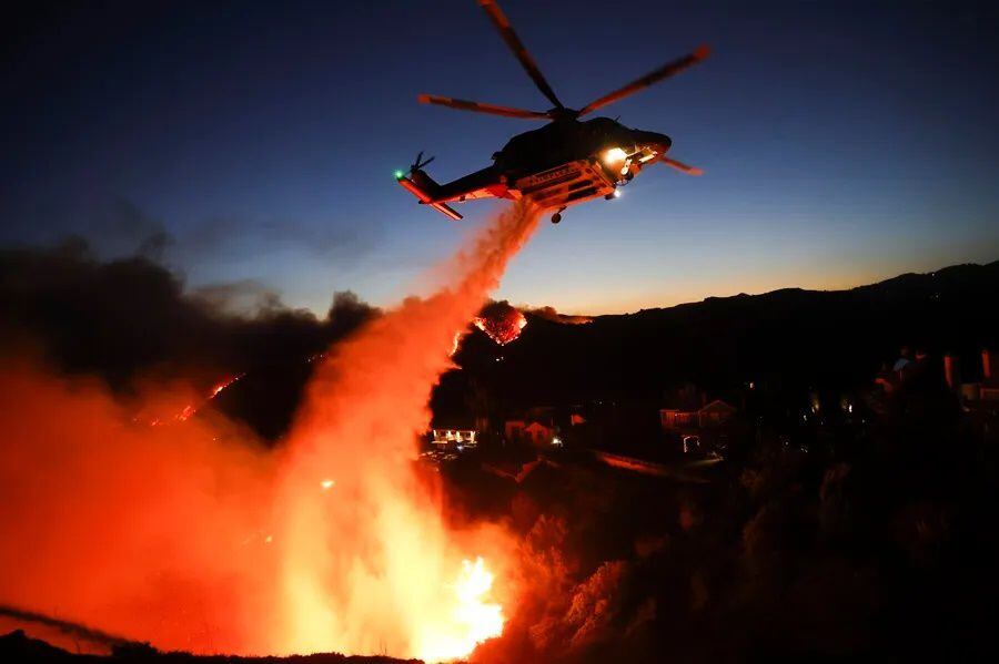 Un helicóptero de bomberos del condado de Los Ángeles lanza agua para combatir el incendio forestal de Palisades en Pacific Palisades, California. Foto: EFE